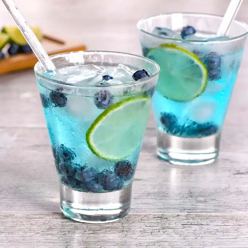 Blue curacao cocktail with blueberries and lime